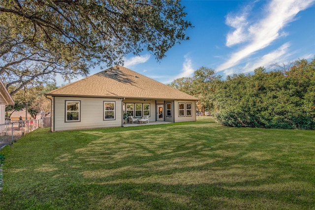 rear view of house featuring a yard and a patio