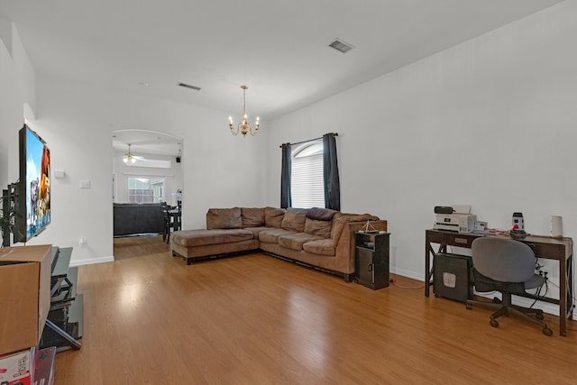 living room featuring light hardwood / wood-style flooring and ceiling fan with notable chandelier