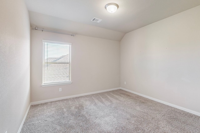 carpeted empty room featuring lofted ceiling