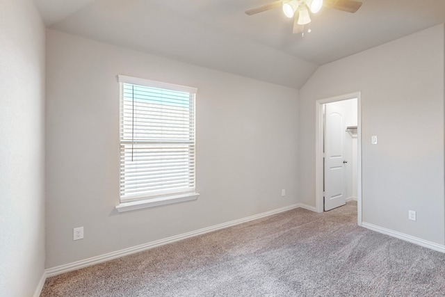 spare room with light carpet, vaulted ceiling, and ceiling fan