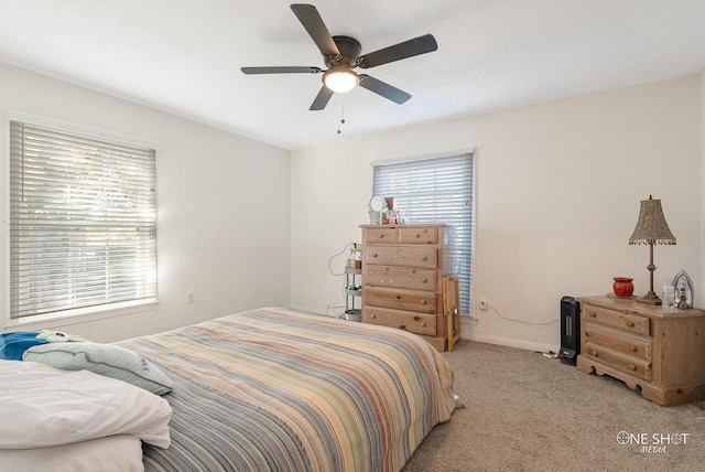 carpeted bedroom featuring ceiling fan and multiple windows