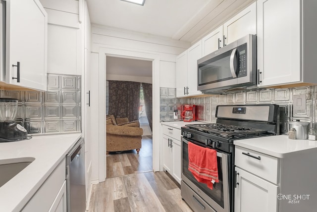 kitchen featuring white cabinets, appliances with stainless steel finishes, and light hardwood / wood-style flooring