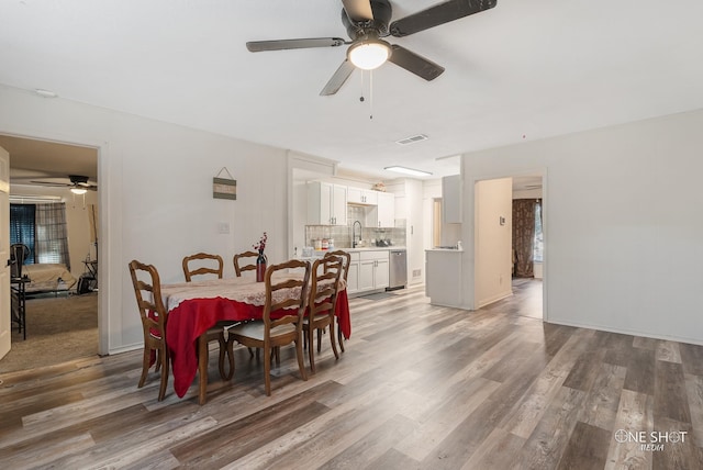 dining area with hardwood / wood-style flooring, ceiling fan, and sink