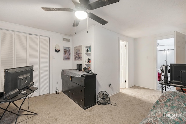 carpeted bedroom with ceiling fan and a closet