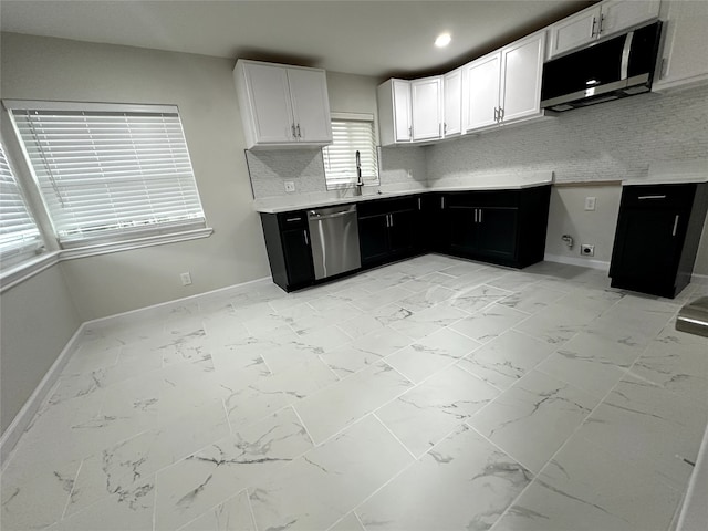 kitchen with backsplash, appliances with stainless steel finishes, sink, and white cabinetry