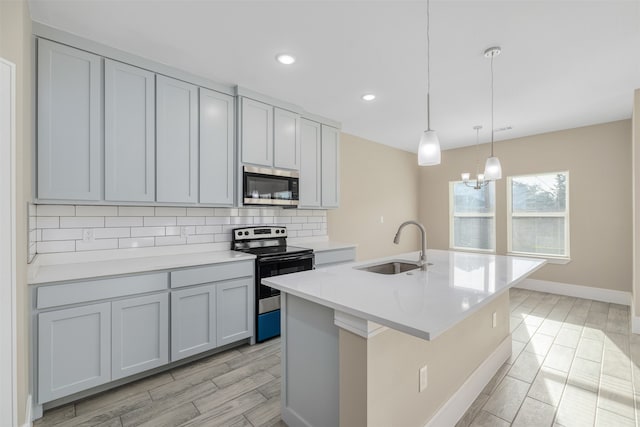 kitchen featuring hanging light fixtures, sink, light hardwood / wood-style floors, and appliances with stainless steel finishes