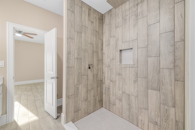 bathroom with ceiling fan and tiled shower