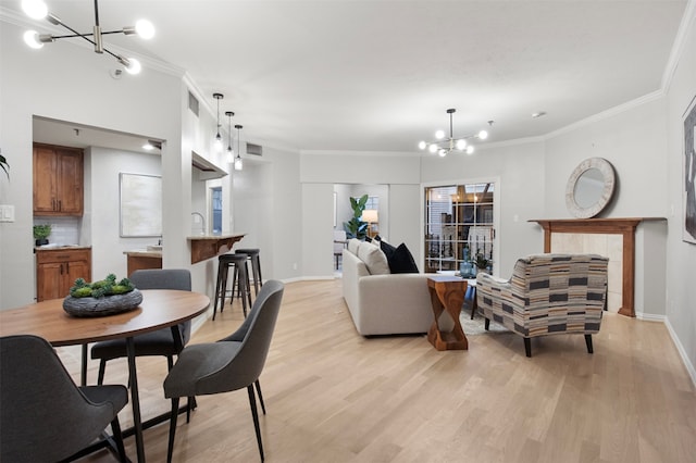 living room featuring a chandelier, light hardwood / wood-style floors, and ornamental molding