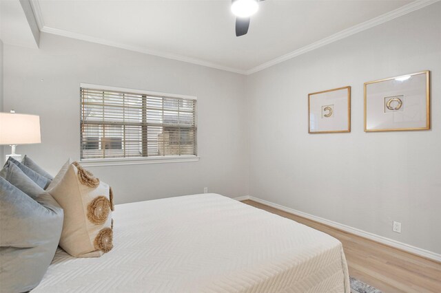 bedroom with light hardwood / wood-style flooring, ceiling fan, and crown molding