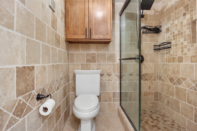 bathroom featuring a shower with door and toilet