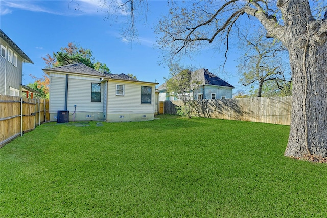 back of house featuring a yard and central AC unit