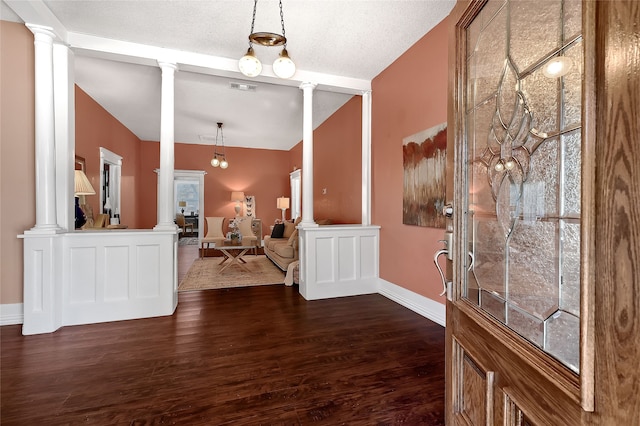 entryway featuring decorative columns, dark hardwood / wood-style flooring, and vaulted ceiling