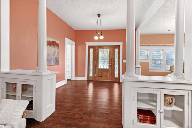 1117 W Bond St, Denison, TX 75020 - entrance foyer featuring decorative columns, dark wood-type flooring, and a textured ceiling