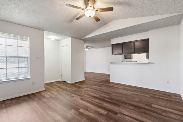 unfurnished living room with a textured ceiling, ceiling fan, lofted ceiling, and dark wood-type flooring