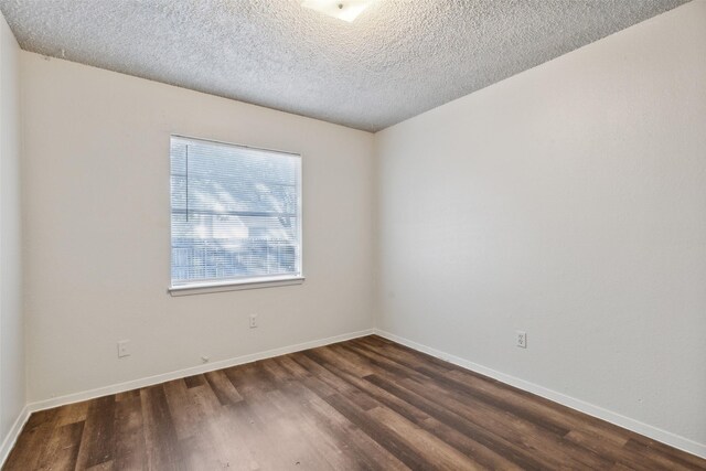 empty room with a textured ceiling and dark wood-type flooring