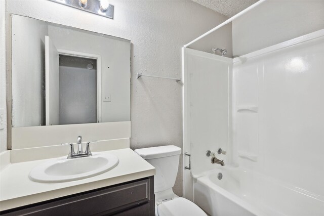 full bathroom featuring vanity, toilet, a textured ceiling, and bathtub / shower combination