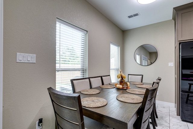 206 Willowbrook Ave, Tyler, TX 75702 - dining room with light marble finish flooring, a textured wall, and baseboards
