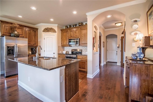 kitchen with dark stone counters, stainless steel appliances, crown molding, dark wood-type flooring, and sink