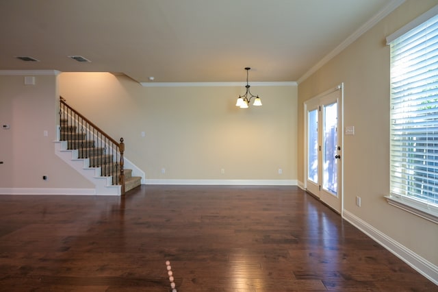 unfurnished room featuring a healthy amount of sunlight, crown molding, dark wood-type flooring, and an inviting chandelier