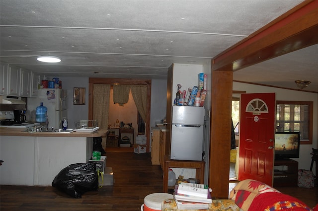 kitchen with black range, white fridge, dark wood-type flooring, and fridge