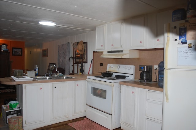 kitchen with white cabinets, white appliances, wooden walls, and sink