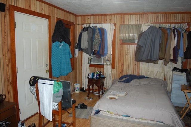 bedroom with hardwood / wood-style floors, wood walls, and cooling unit