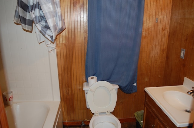 bathroom with vanity, toilet, and wooden walls