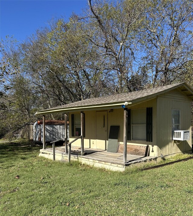 rear view of property featuring cooling unit and a yard