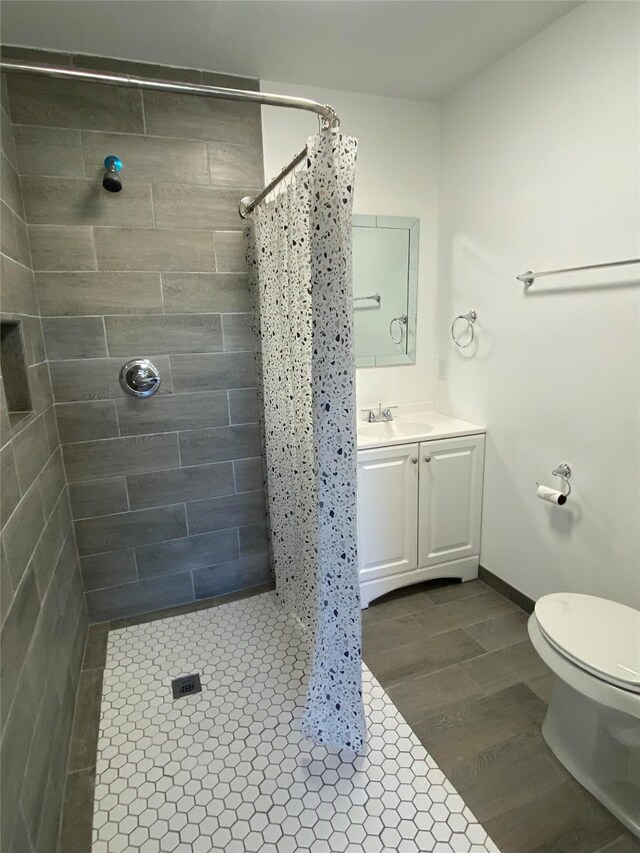 bathroom with curtained shower, toilet, vanity, and hardwood / wood-style flooring