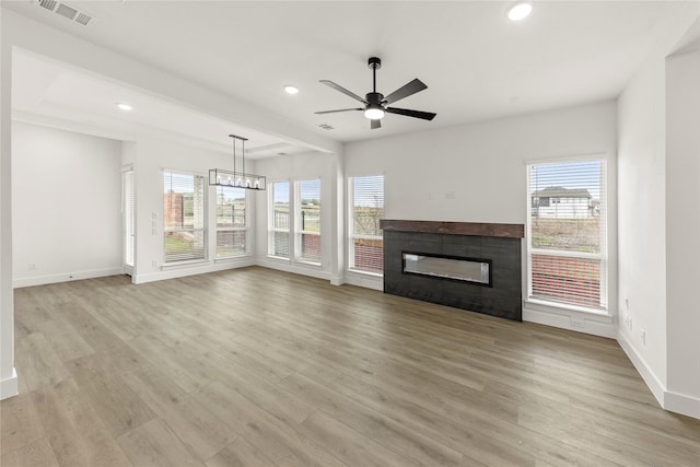 3100 Summer Rain Ln, Anna, TX 75409 - unfurnished living room featuring healthy amount of natural light, a tiled fireplace, recessed lighting, ceiling fan, and light wood-style floors
