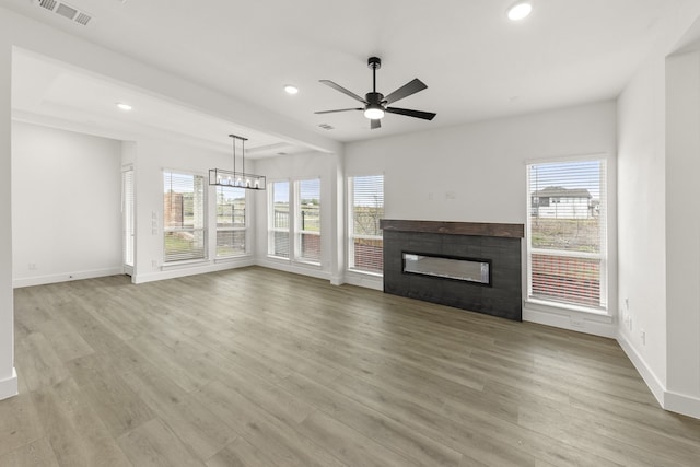 3100 Summer Rain Ln, Anna, TX 75409 - unfurnished living room featuring healthy amount of natural light, recessed lighting, a glass covered fireplace, a ceiling fan, and wood finished floors