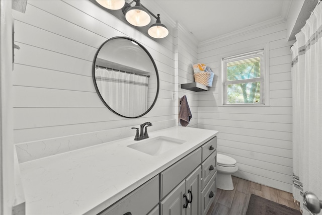 bathroom featuring vanity, crown molding, wood-type flooring, toilet, and wood walls