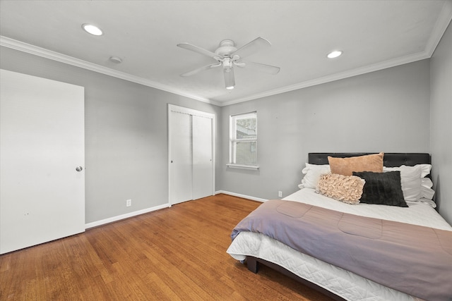 bedroom featuring wood-type flooring, a closet, ceiling fan, and crown molding