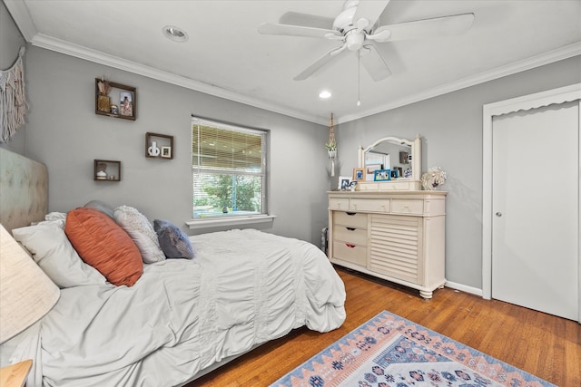 bedroom with a closet, ceiling fan, crown molding, and light hardwood / wood-style floors