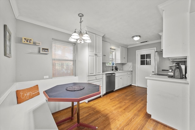 kitchen featuring dishwasher, white cabinets, sink, hanging light fixtures, and light wood-type flooring