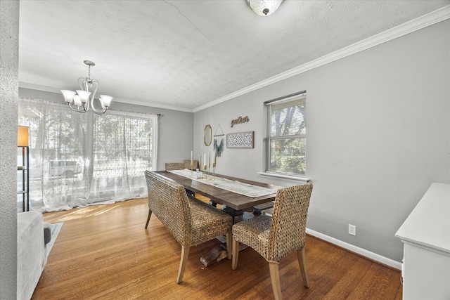 dining space featuring a wealth of natural light, crown molding, a chandelier, and hardwood / wood-style flooring