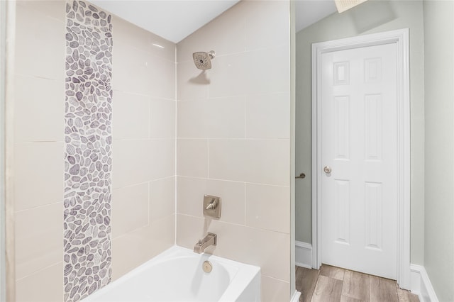 bathroom featuring hardwood / wood-style flooring, lofted ceiling, and shower / tub combo