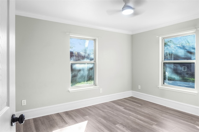 empty room featuring a wealth of natural light, ceiling fan, light hardwood / wood-style floors, and ornamental molding