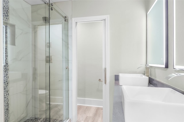 bathroom with hardwood / wood-style floors, vanity, toilet, and walk in shower