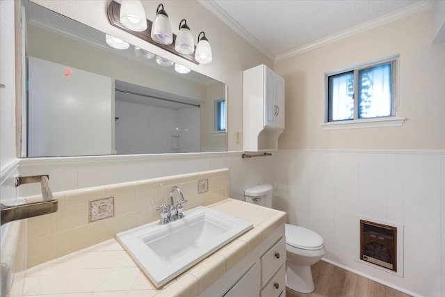 bathroom featuring backsplash, crown molding, wood-type flooring, toilet, and vanity