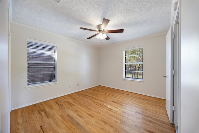 empty room featuring ceiling fan, ornamental molding, a textured ceiling, and light wood-type flooring