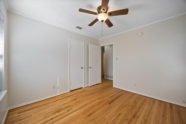 empty room featuring crown molding, ceiling fan, a textured ceiling, and light wood-type flooring