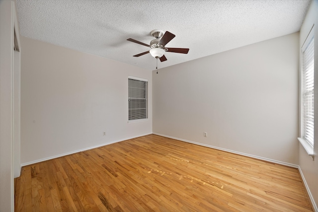 unfurnished room with a textured ceiling, light hardwood / wood-style floors, and plenty of natural light