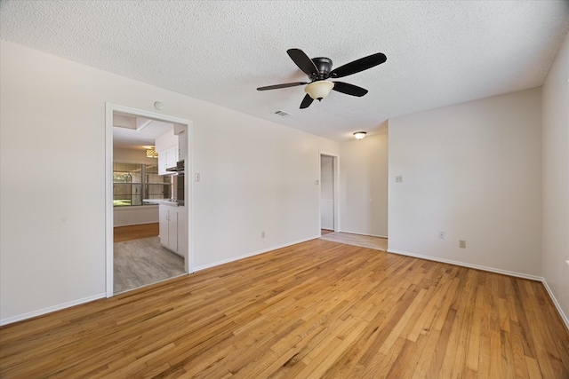 spare room with a textured ceiling, light hardwood / wood-style flooring, and ceiling fan