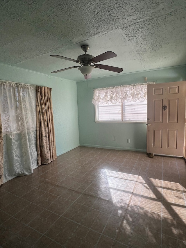 unfurnished room featuring ceiling fan and a textured ceiling