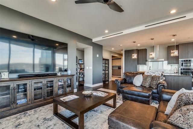 living room with ceiling fan with notable chandelier