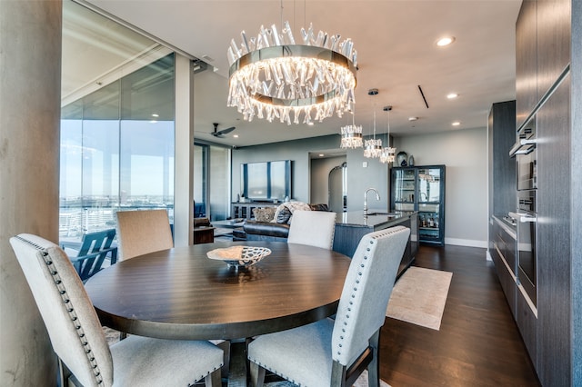 dining area with dark hardwood / wood-style flooring, ceiling fan with notable chandelier, and sink