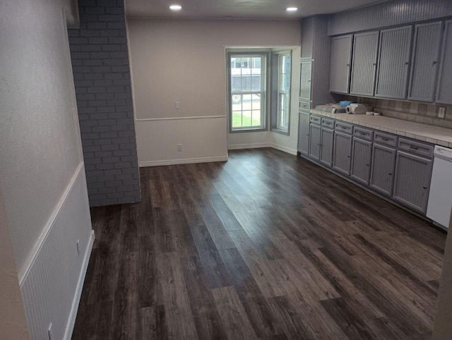 kitchen with gray cabinetry, dark wood-type flooring, and white dishwasher