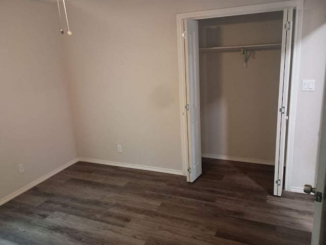 unfurnished bedroom with a closet and dark hardwood / wood-style floors