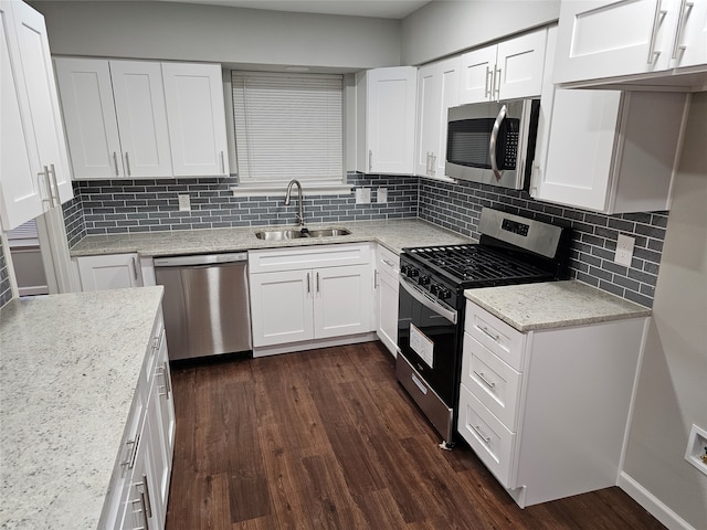 kitchen with dark wood-type flooring, sink, tasteful backsplash, white cabinetry, and stainless steel appliances